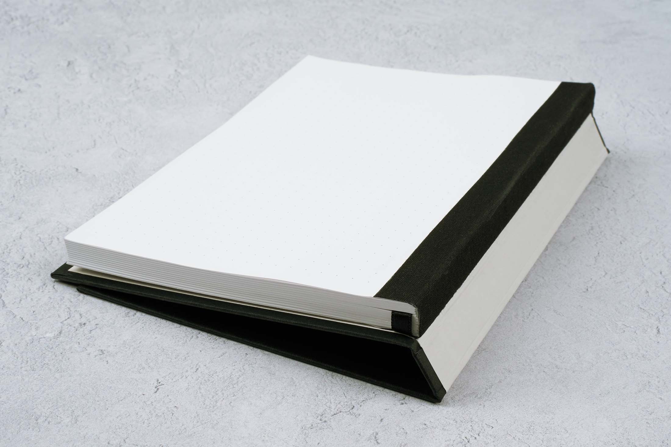 the paper mind blocker paper notebook folded over showing the Swiss binding and Gmund blocker paper sheets