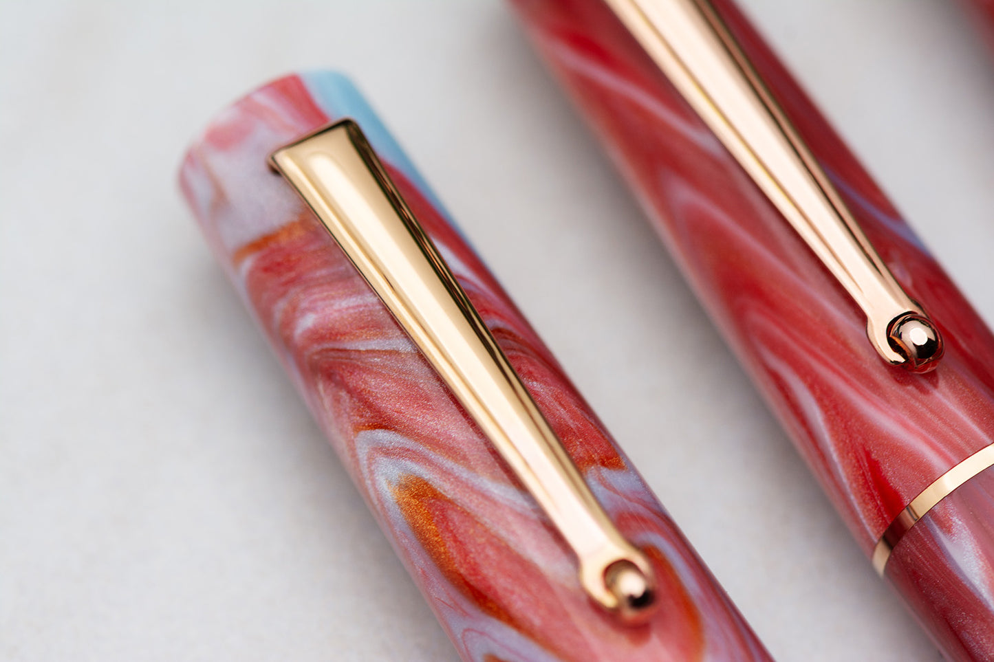 Marbled pen with gold accents on a light background Delta Duna Ghibli Red Fountain Pen cap detail made in Italy