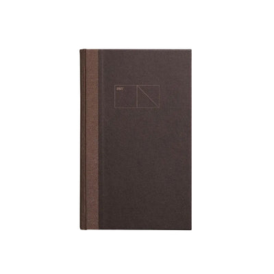 A dark brown hardcover notebook or journal with a textured cover and a matching brown spine, featuring a minimalist geometric line drawing on the front cover, set against a clean light gray background. Papierniczeni Copper 2027 Calendar – Chocolate