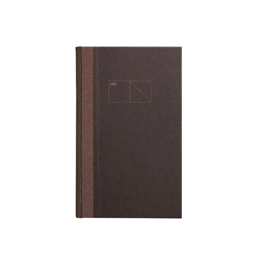 A dark brown hardcover notebook or journal with a textured cover and a matching brown spine, featuring a minimalist geometric line drawing on the front cover, set against a clean light gray background. Papierniczeni Copper 2027 Calendar – Chocolate