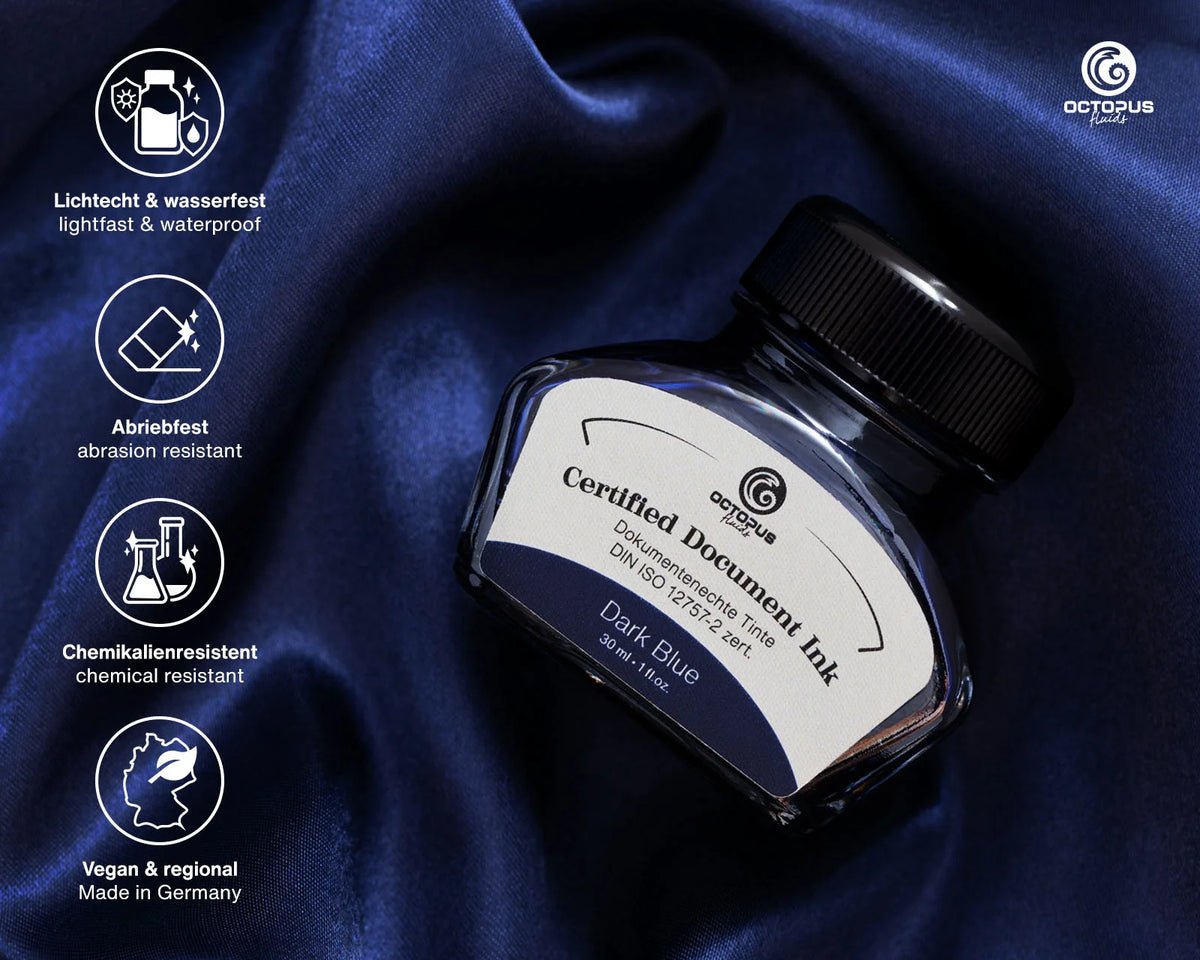 Octopus Certified Document Ink in Dark Blue, presented in a dark glass bottle with a black cap on a draped navy blue satin fabric background, with feature icons on the left. Octopus Fluids Fountain Pen Document Ink - 30 ml Bottle - Dark Blue -  Made in Germany