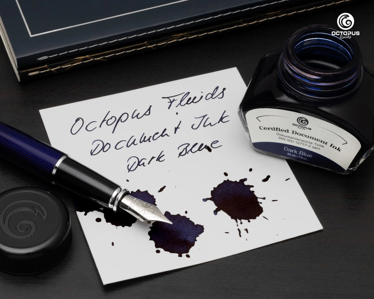 Dark blue ink bottle, fountain pen, and ink splashes on a white paper with 'Octopus' branding. Octopus Fluids Fountain Pen Document Ink - 30 ml Bottle - Dark Blue -  Made in Germany