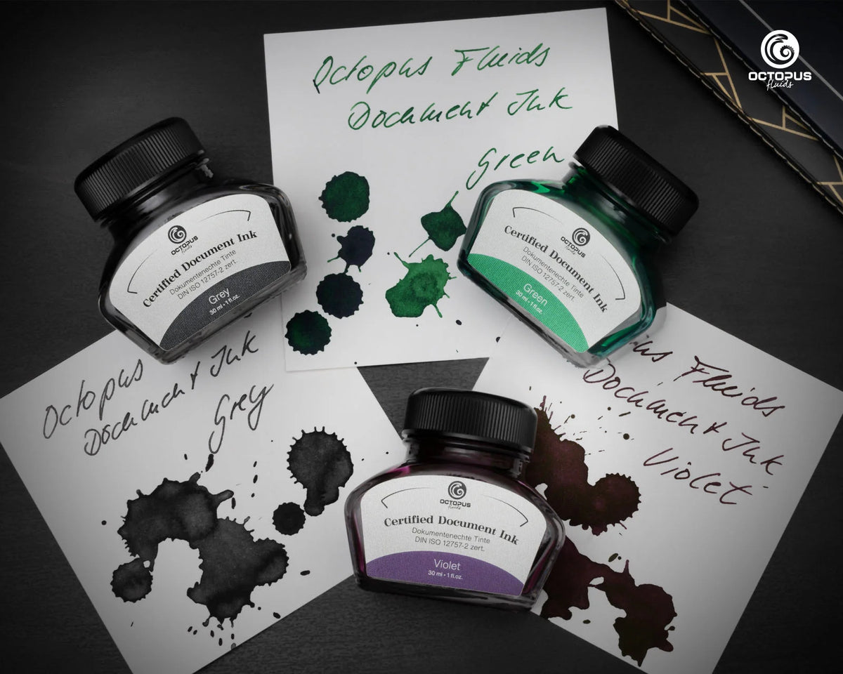 Three bottles of Octopus Ink with ink splashes and labels on a dark surface.