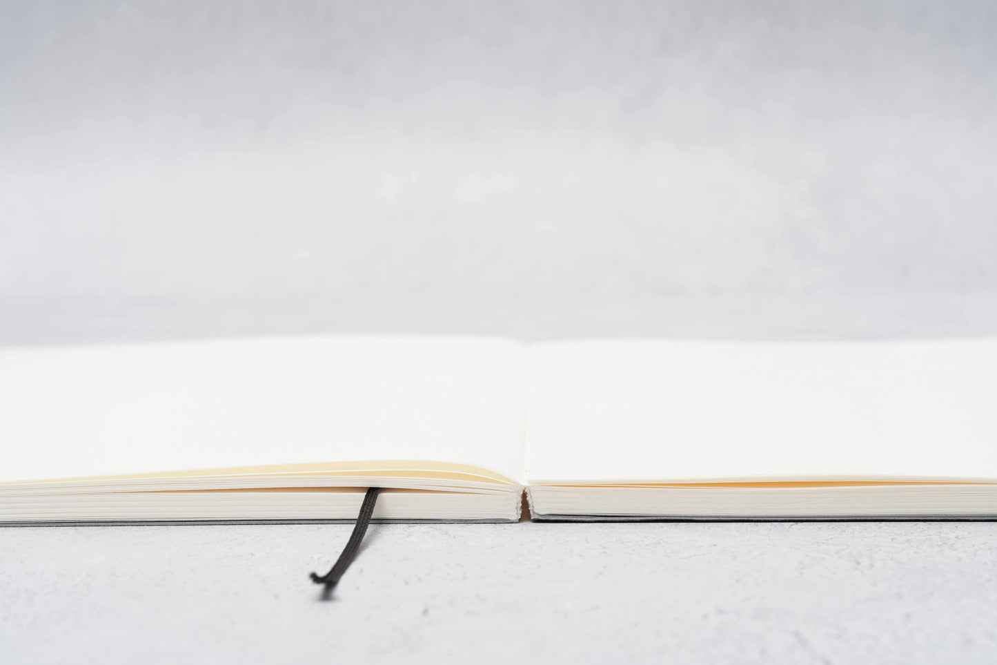 Paper Mind Mitsubishi Notebook Laying Flat on Gray surface showing spine edge