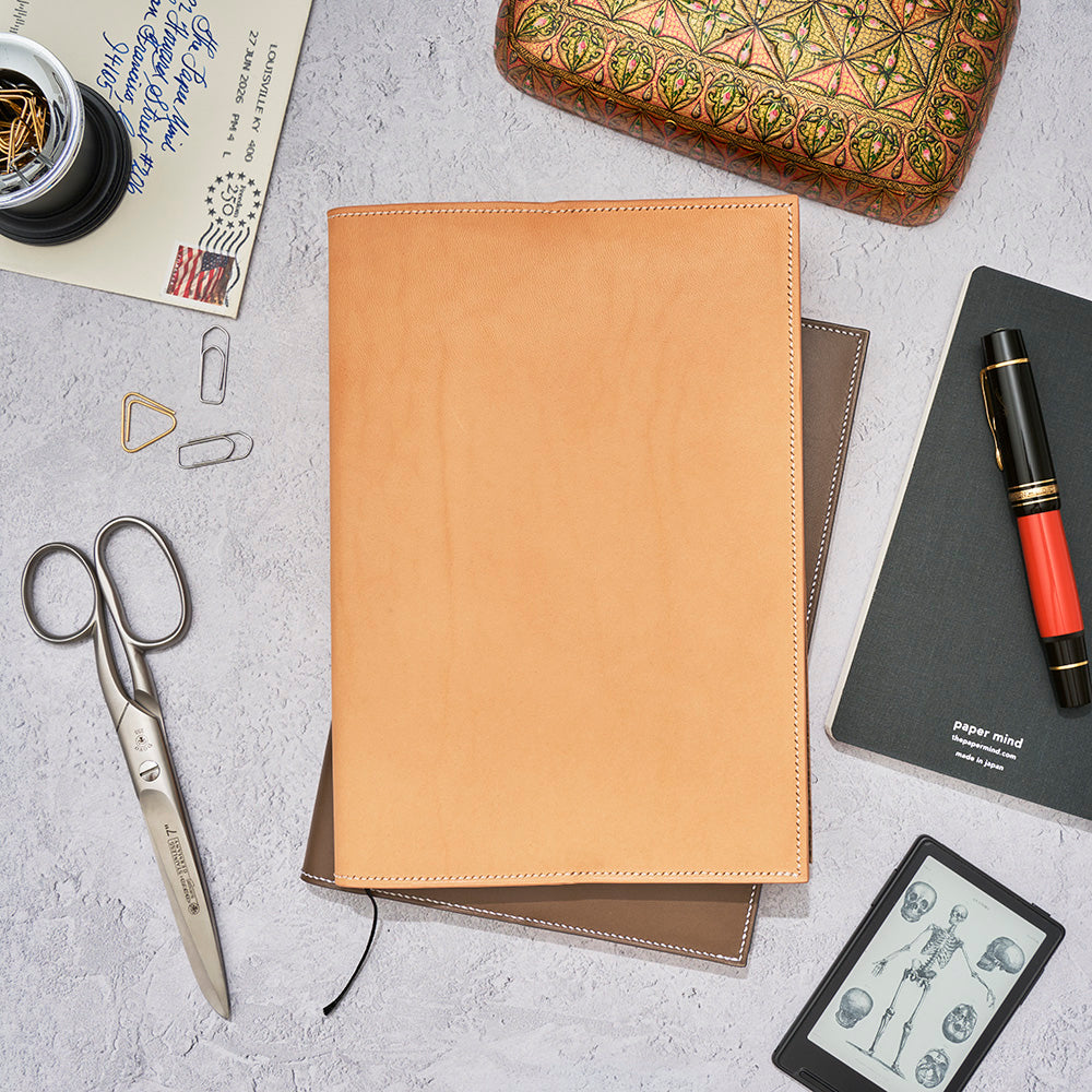 The Paper Mind Notebook Cover - A5 - Hand-Stitched Buttero Leather stacked with accessories. 