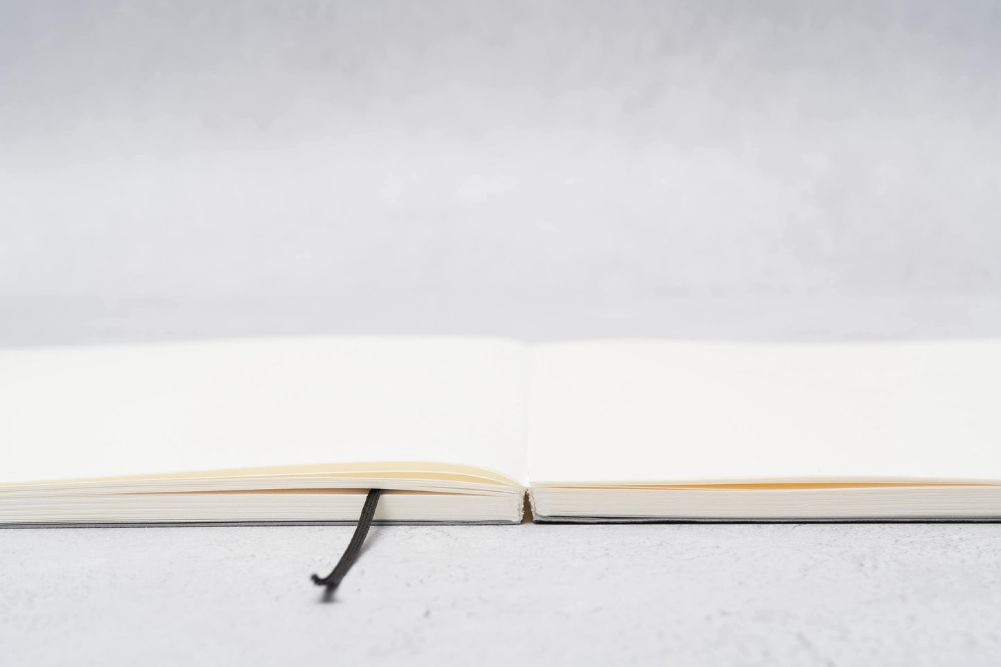 Paper Mind Mitsubishi Notebook Laying Flat on Gray surface showing spine edge