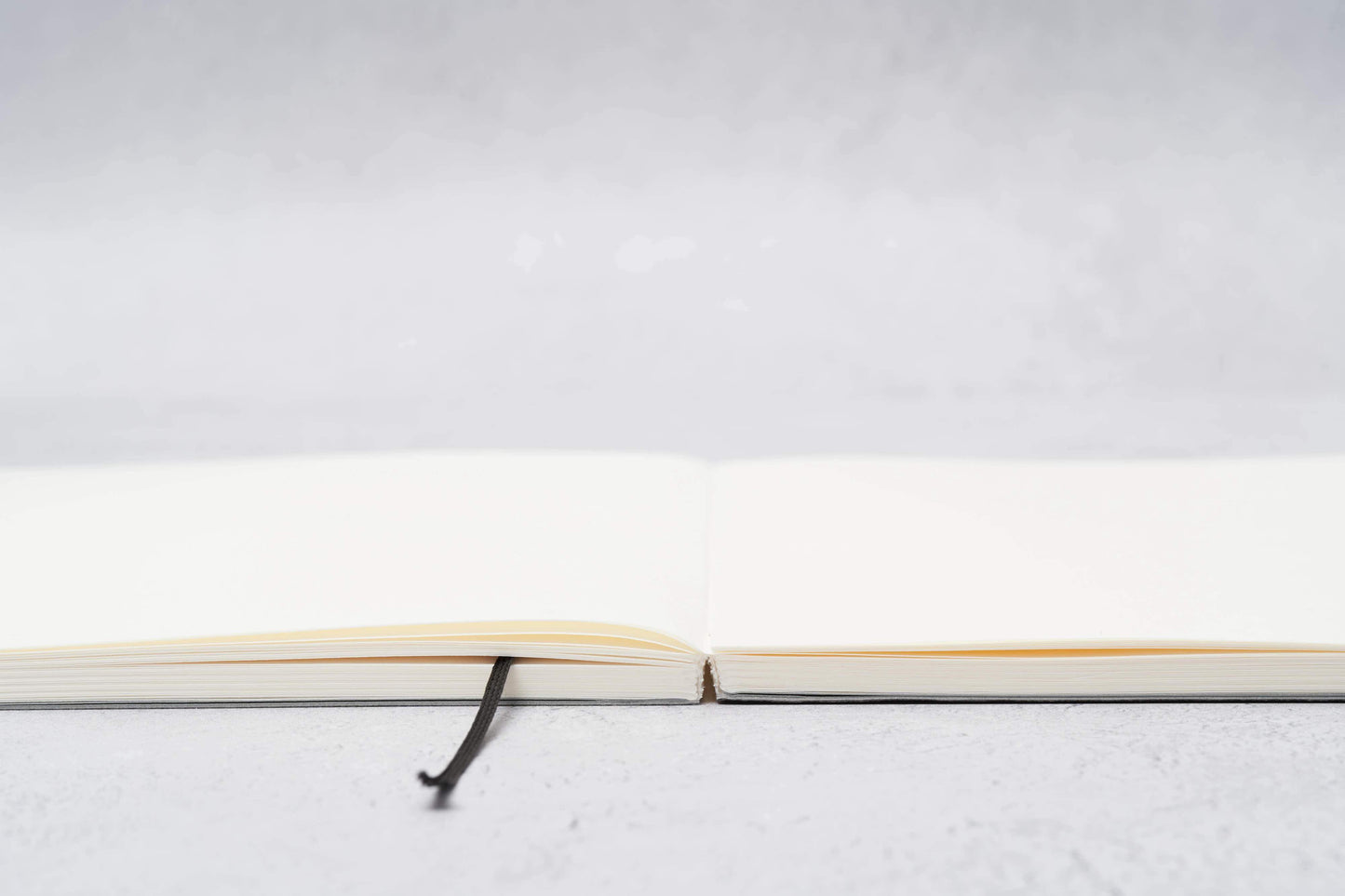 Paper Mind Mitsubishi Notebook Laying Flat on Gray surface showing spine edge
