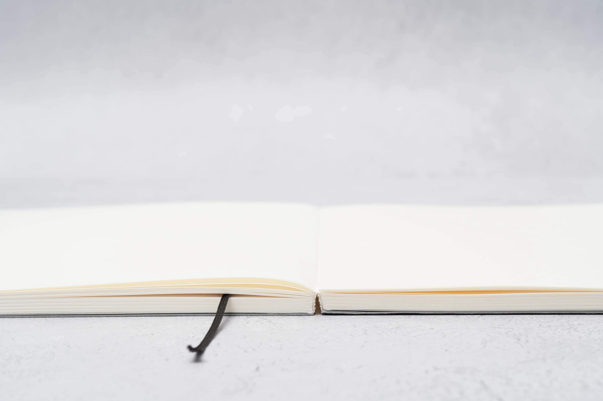 Paper Mind Mitsubishi Notebook Laying Flat on Gray surface showing spine edge